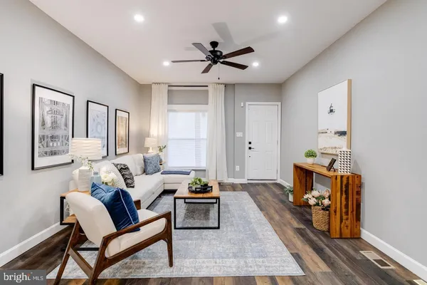 a living room with furniture and a wooden floor