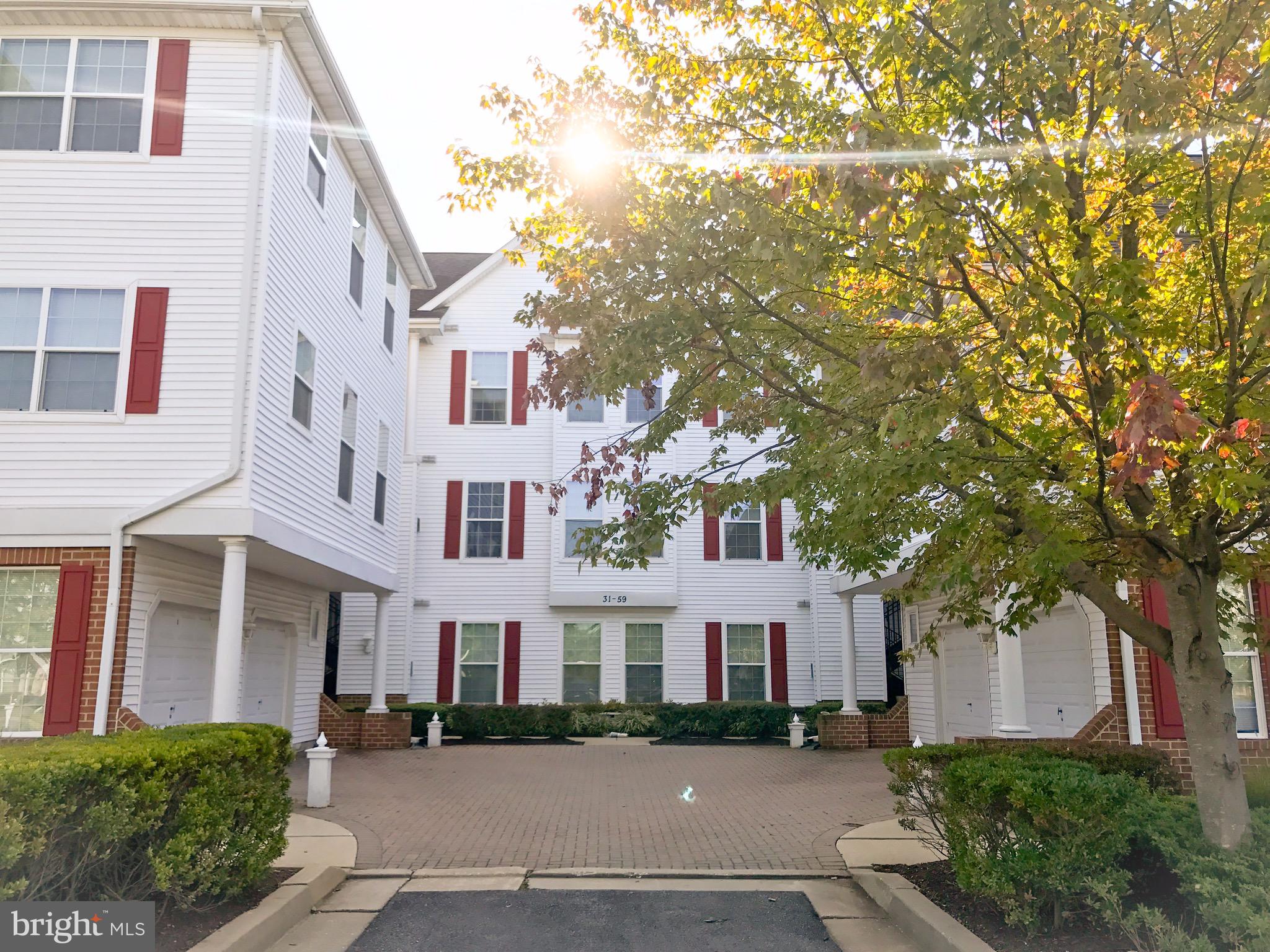 a front view of a residential houses with yard and trees