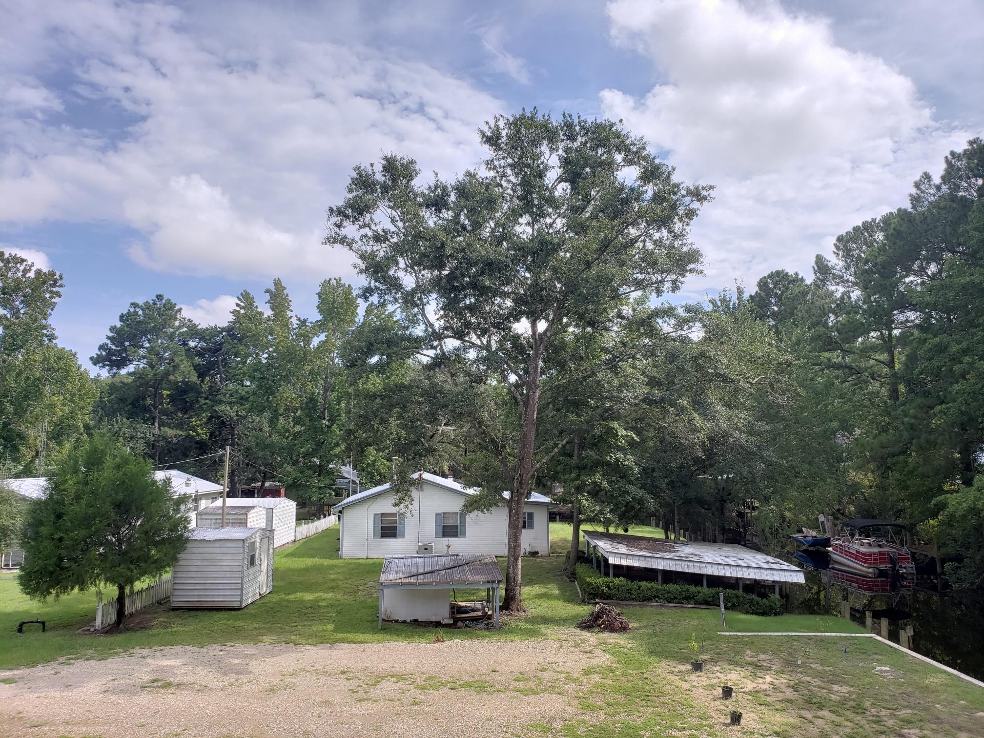 a view of house with swimming pool and trees in the background