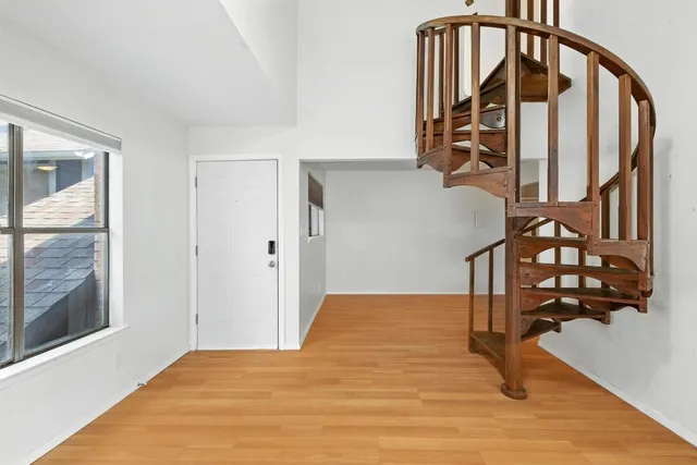 a view of staircase with wooden floor and windows