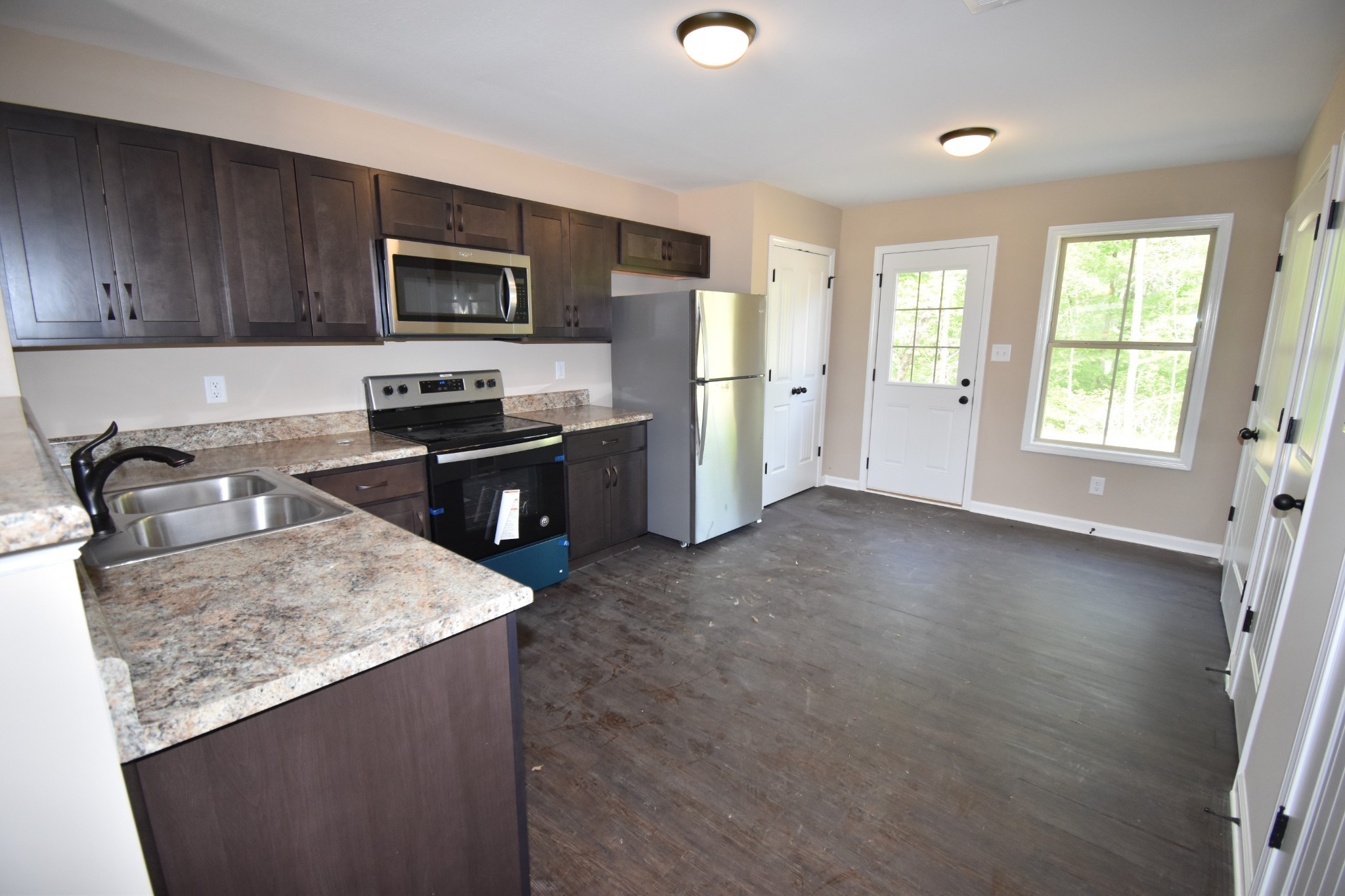 255 Smithson Lane, Unit B Clarksville, TN 37040 - Photo 4 of 21 a kitchen with stainless steel appliances granite countertop a stove a sink dishwasher a refrigerator and a microwave oven with wooden floor