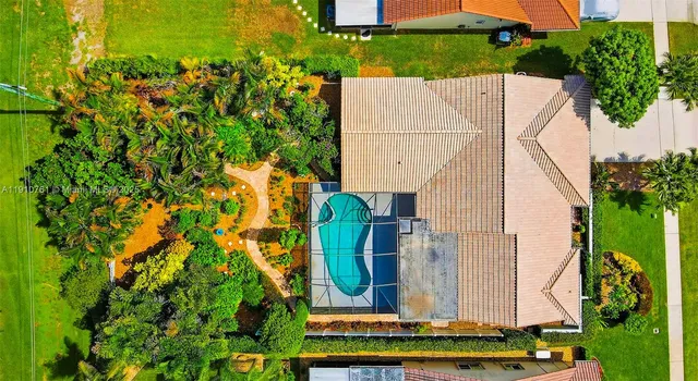 an aerial view of a house with a yard and trees