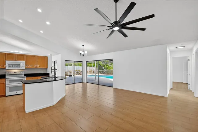 a kitchen with stainless steel appliances a refrigerator a sink a stove and white cabinets