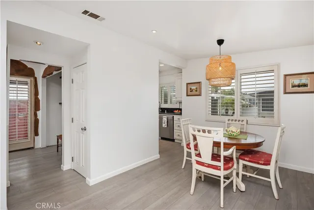 a living room with furniture kitchen view and a wooden floor