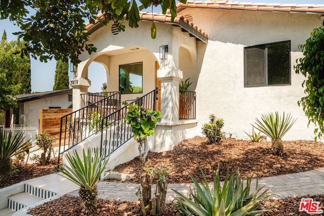 a front view of a house with a garden