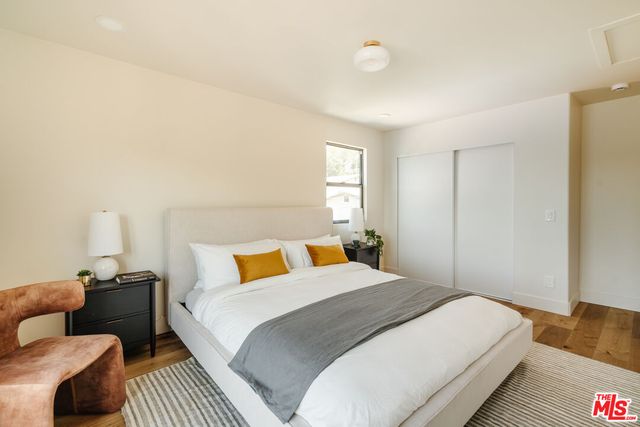 a bedroom with a bed and wooden floor