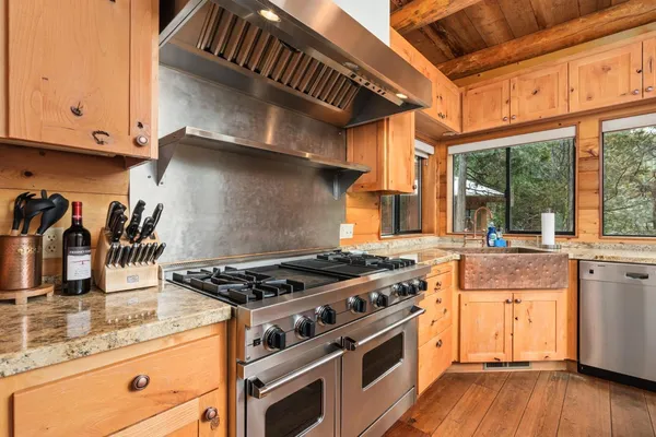 a kitchen with stainless steel appliances granite countertop a stove and cabinets