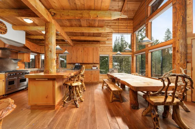 a kitchen with stainless steel appliances kitchen island granite countertop a table chairs in it and wooden floors