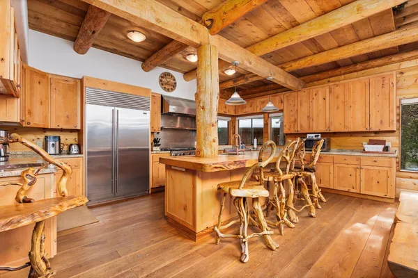 a kitchen with stainless steel appliances granite countertop a refrigerator a stove and a sink