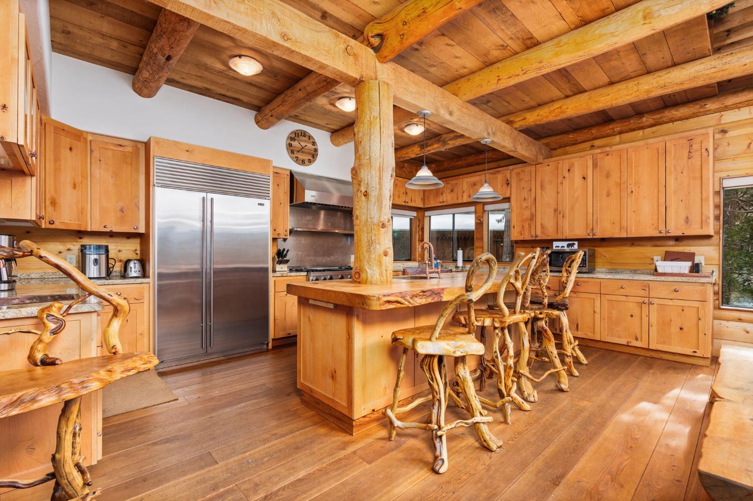 39553 Crest Point Lane Shaver Lake, CA 93664 - Photo 9 of 65 a kitchen with stainless steel appliances kitchen island granite countertop a table chairs in it and wooden floors