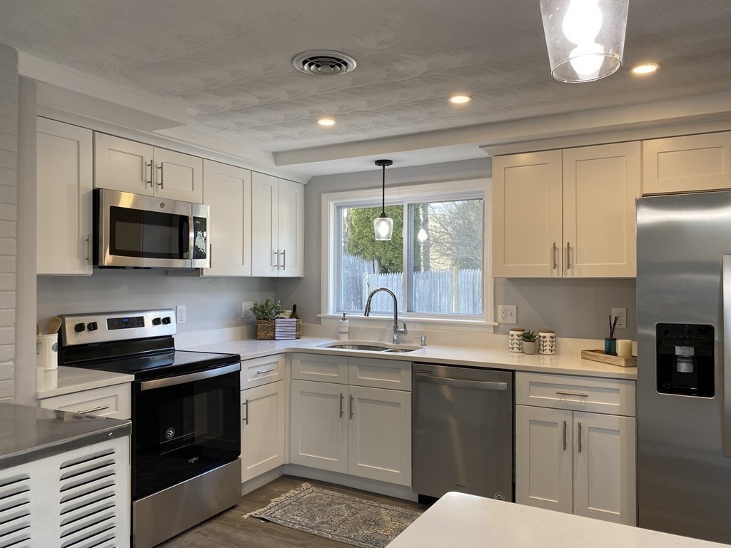 82 Griffin Road Framingham, MA 01701 - Photo 3 of 39 a kitchen with a sink stove and microwave