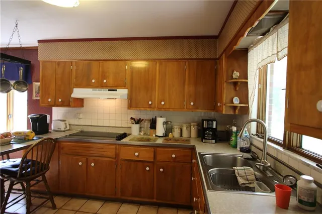a kitchen with sink a stove and chairs
