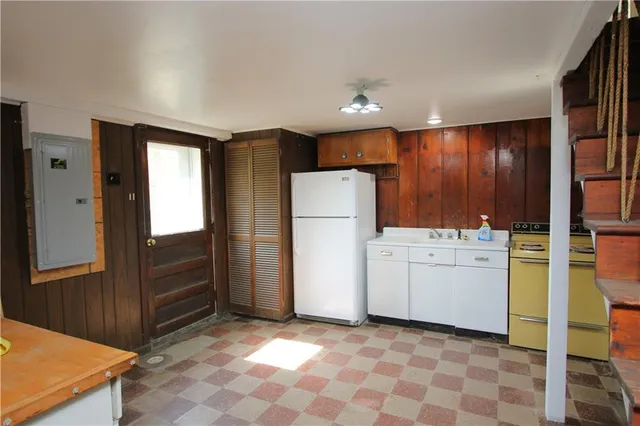 a view of kitchen with refrigerator and cabinet