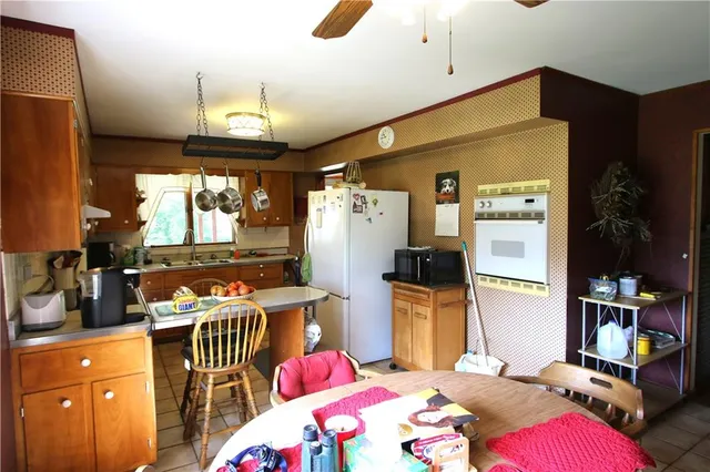 a bedroom with furniture a flat screen tv and a refrigerator