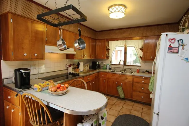 a kitchen with a sink a stove and chairs