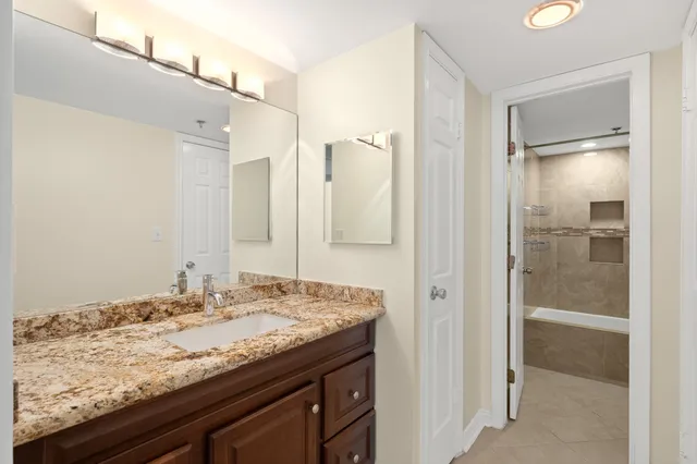 a bathroom with a granite countertop sink and a mirror