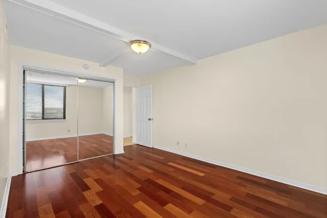 a view of empty room with wooden floor