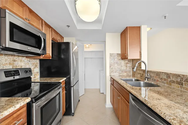 a kitchen with stainless steel appliances granite countertop a sink stove and microwave