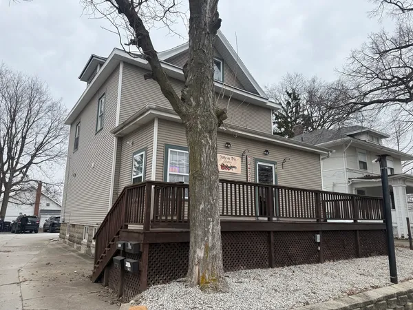 a view of a house with a wooden deck front of house