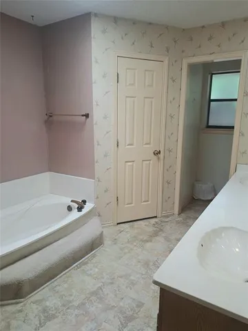 a spacious bathroom with a bathtub and a shower