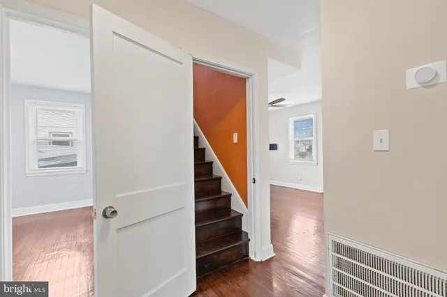 a view of a hallway with wooden floor and staircase