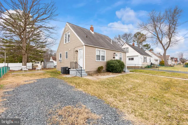 a view of a house with a yard and large trees