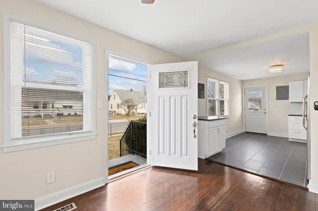 a view of a livingroom with wooden floor and a kitchen space