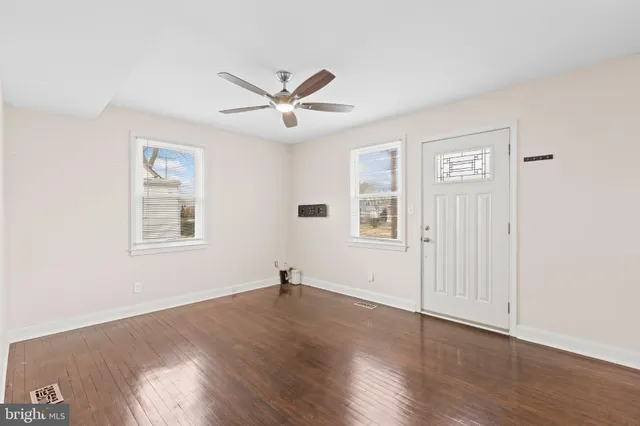 a view of a big room with wooden floor and windows in a room