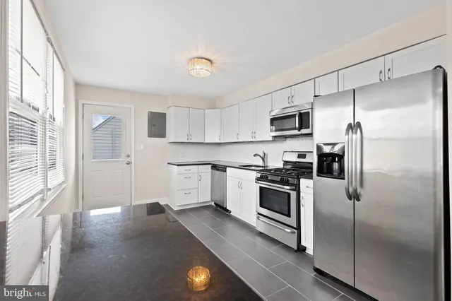 a kitchen with granite countertop a refrigerator stove and microwave