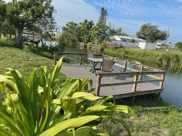 a view of a garden with lawn chairs under an umbrella