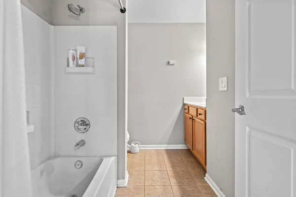 a bathroom with a tub shower and a sink