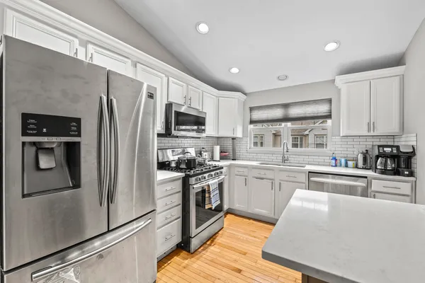 a kitchen with stainless steel appliances granite countertop a refrigerator sink and stove