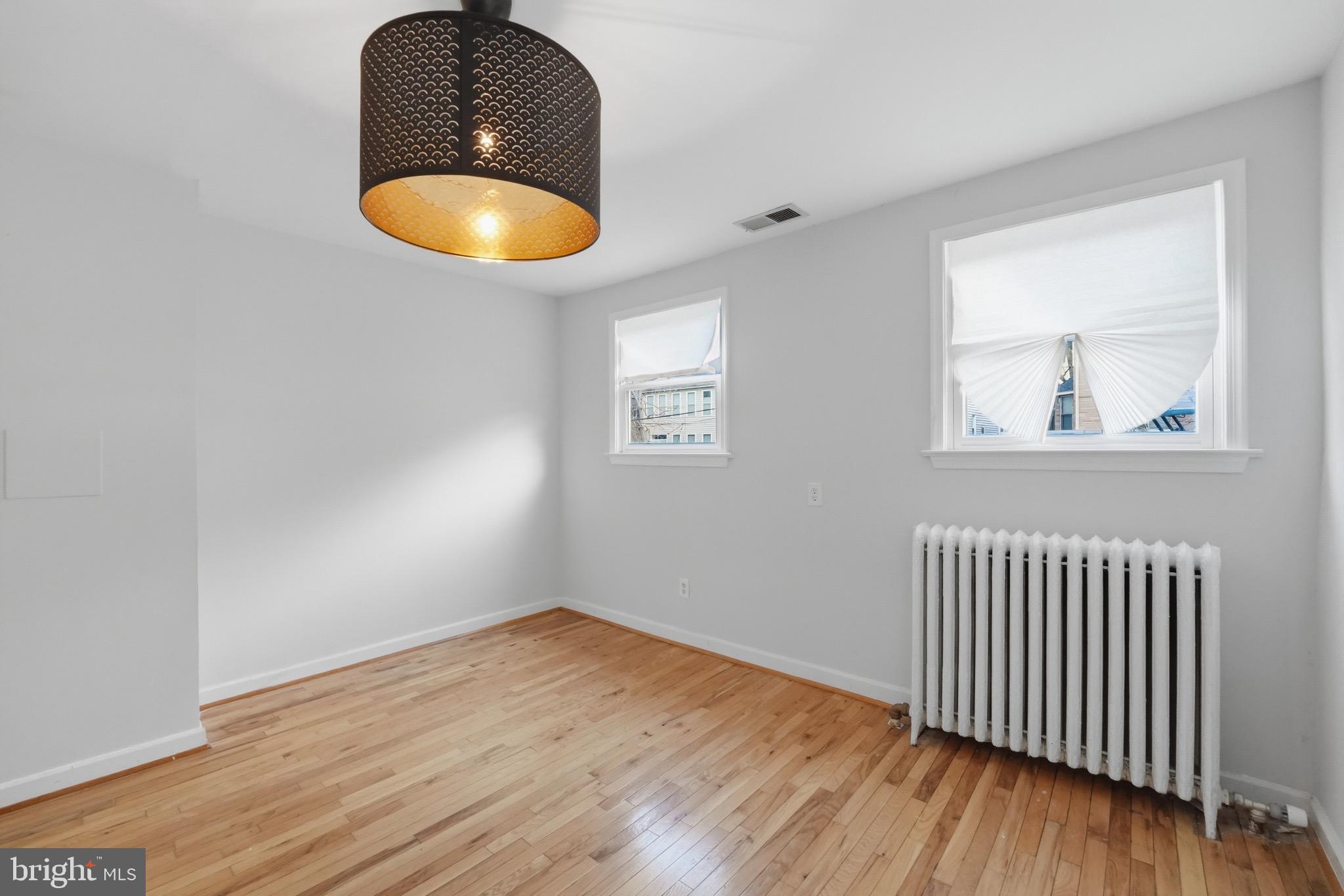 1310 Emerson Street Northwest Washington, DC 20011 - Photo 13 of 38 an empty room with wooden floor and windows