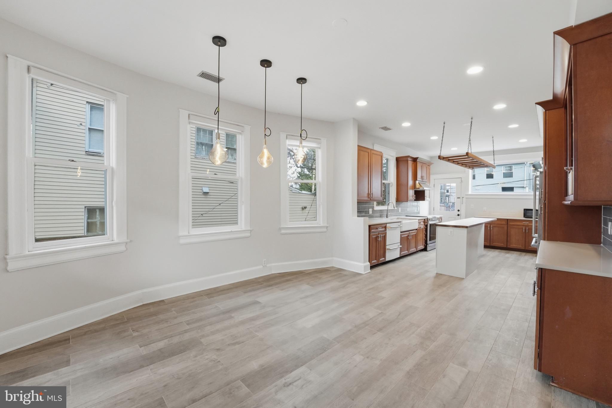 1310 Emerson Street Northwest Washington, DC 20011 - Photo 10 of 38 a kitchen with stainless steel appliances kitchen island granite countertop a refrigerator a sink dishwasher and a wooden cabinets