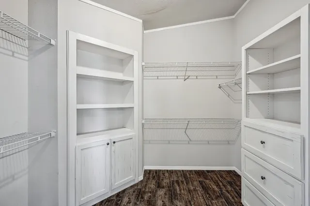 a view of walk in closet with empty racks