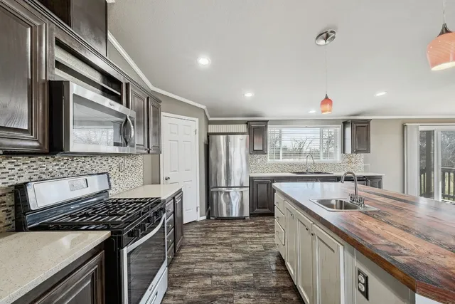 a kitchen with stainless steel appliances granite countertop a sink stove and refrigerator