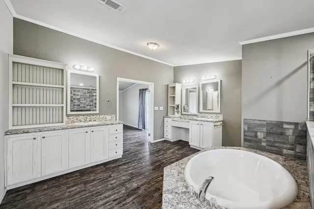 a bathroom with a tub sink and mirror