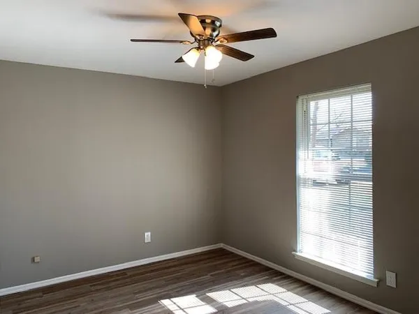 wooden floor in an empty room with a window
