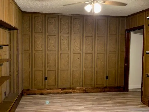 an empty room with wooden floor and entryway
