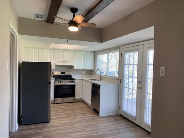 a kitchen with stainless steel appliances granite countertop a refrigerator and a stove top oven