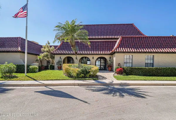 a front view of a house with garage and plants