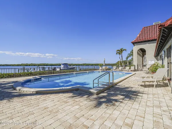 a view of a swimming pool with seating area and barbeque oven