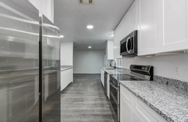 a kitchen with stainless steel appliances granite countertop a refrigerator and a sink