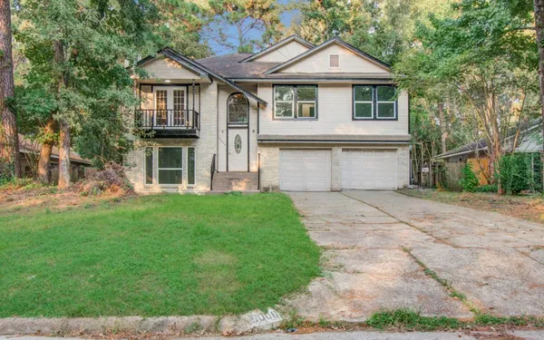 a front view of a house with a yard and trees