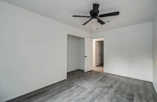 a view of a livingroom with a ceiling fan and wooden floor