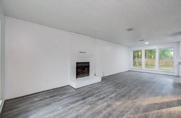 a view of empty room with wooden floor and fireplace