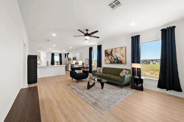 a living room with furniture and wooden floor