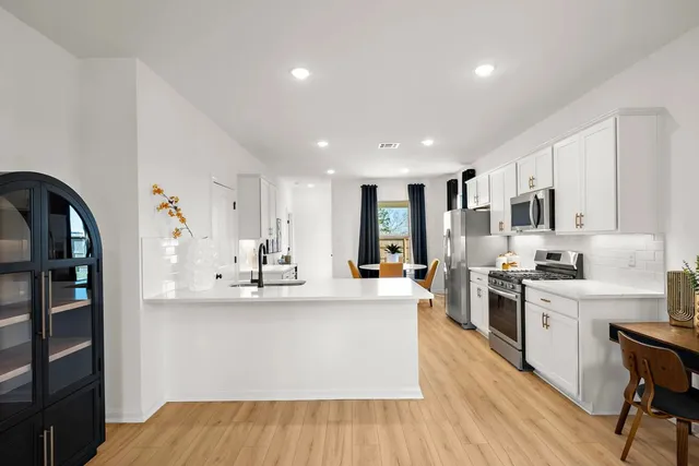 a large white kitchen with stainless steel appliances