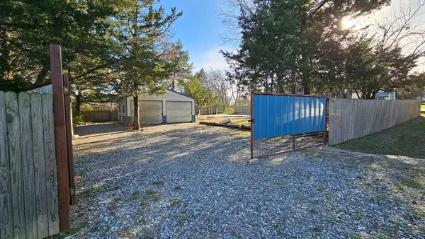a view of a house with a yard and large tree