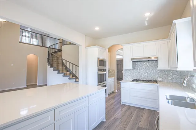 a kitchen with stainless steel appliances granite countertop a sink and cabinets